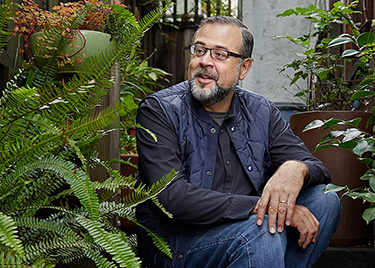 Campos sits outdoors at his home